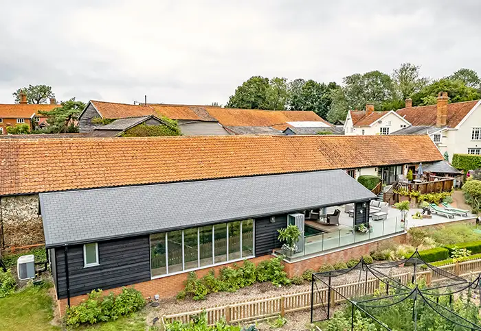 External distant view of an indoor pool house with a heated pool