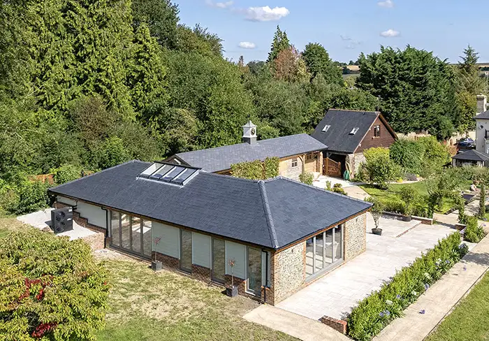 External distant view of an indoor pool house with a heated pool