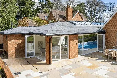 A pool extension viewed from the outside also showing the hosue it is attached to