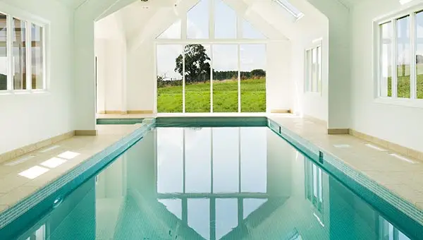 looking out across indoor pool to large window at the end